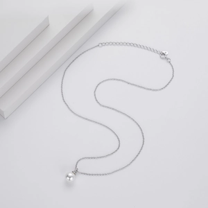 Macro shot of minimalist S925 sterling silver chain and polished white pearl pendant