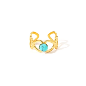 Détail d'une bague goutte dorée avec incrustation de turquoise sur fond blanc pur