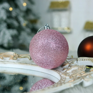 Pink glitter Christmas ball ornament with silver hook on white vintage tray