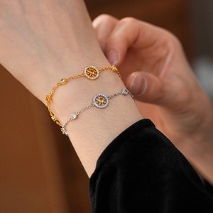 Close-up of gold and silver eight-pointed star bracelets with zircon on a woman's wrist