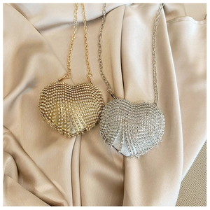 Detailed view of mini heart-shaped evening bags with sparkling rhinestones in gold and silver