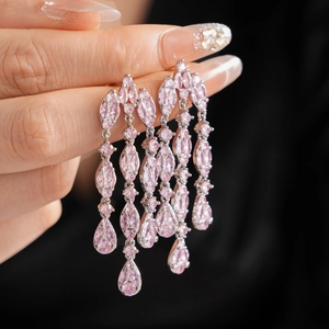 Detail of pink zircon water drop tassel earrings on silver settings held by hand