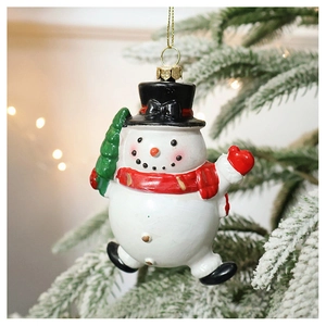 Detail of snowman Christmas ornament with red scarf on a decorated tree branch