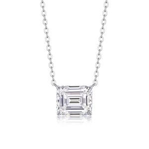 Macro view of emerald cut moissanite pendant necklace with silver claw setting