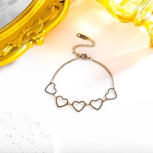 Elegant stainless steel hollow heart chain bracelet displayed with vintage gold frame decor