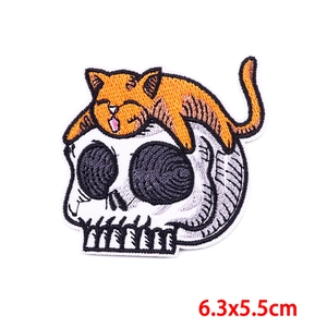 Embroidered iron-on patch featuring an orange tabby cat on a white skull, 6.3x5.5cm