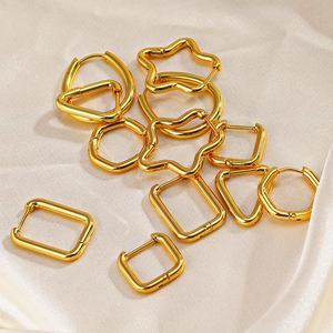 Golden stainless steel geometric earring set with stars and hearts on silk background