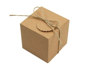 Macro view of square kraft paper gift box with twine rope and scalloped tag detail