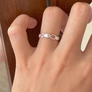 Close-up of minimalist 925 silver chain ring worn on finger with a lifestyle background