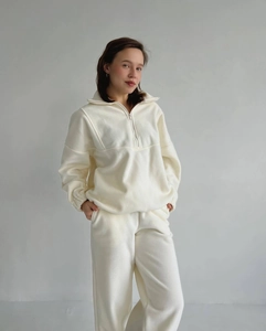 Détail du tissu polaire crème doux sur l'ensemble sweat à demi-zip et pantalon droit