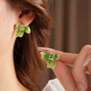 Detail view of flower leaf earrings with green finish and rectangular crystals inlay