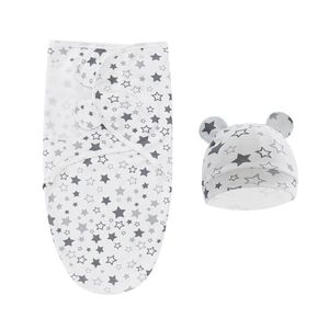 Close-up of white newborn swaddle with gray stars and bear ear hat on white background