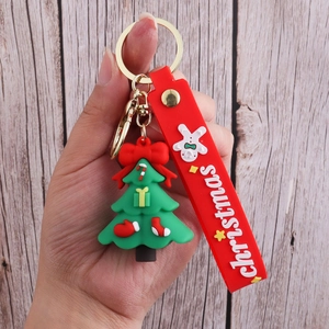 Detailed view of 3D PVC Christmas tree keychain with red strap and gold hardware