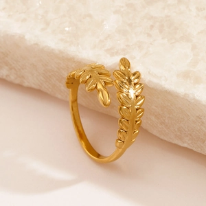 Elegant gold leaf-shaped stainless steel open ring displayed on white textured stone