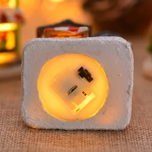 Bottom view of lighted Christmas resin house showing power switch and battery compartment