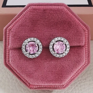 Detailed top view of pink halo zircon stud earrings in a velvet jewelry box