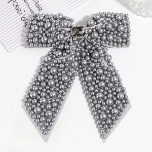 Macro shot of gray ribbon bow hair clip with faux pearls and rhinestone centerpiece