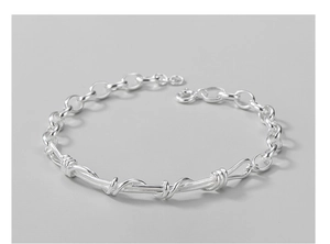 Macro shot of silver-plated twisted wire bracelet featuring a unique thorn chain design