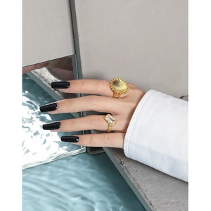 Minimalist S925 silver gold rings with zircons and textured finish on a mirror surface