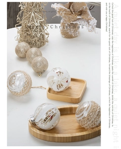 Close-up of decorative Christmas ornaments with white glitter stripes and gold sparkles