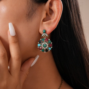 Close-up of vintage floral stud earring with colorful rhinestones on model's ear