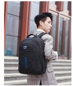 Outdoor shot of the large capacity black and blue sports backpack worn by a male model