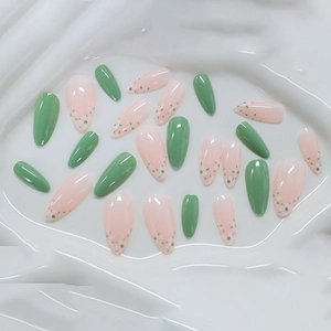 Glossy green and floral almond fake nails set on a white wavy texture background