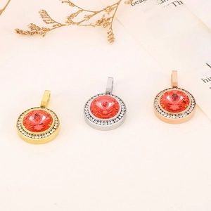 Dettaglio dei pendenti tondi in cristallo rosso in oro, argento e oro rosa