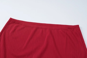 Gros plan de la taille d'une jupe en maille rouge montrant la texture du tissu