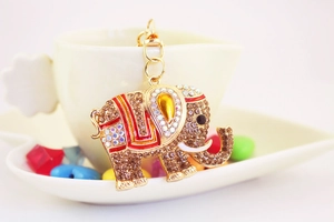 Détail du porte-clés éléphant orné de strass brillants et d'émail coloré sur une tasse