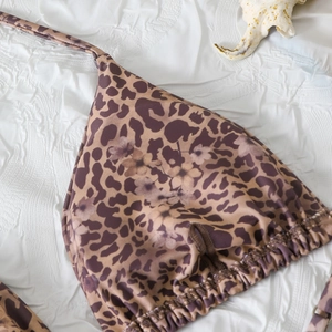 Detailed macro view of leopard and floral print halter bikini top with ribbed texture
