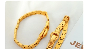 Detailaufnahme des goldenen Titanstahl-Schnallenarmbands mit H-Gliederkette und mattem Finish