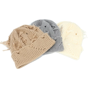 Detailed view of distressed knit texture and ripped details on various color beanies