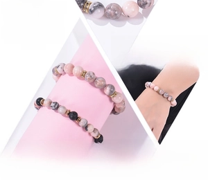 Macro detail of 8mm pink zebra stone and black lava beads with gold spacer accents