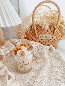 Detailed view of dessert style soy candle with honey bee decor and wooden stirrer