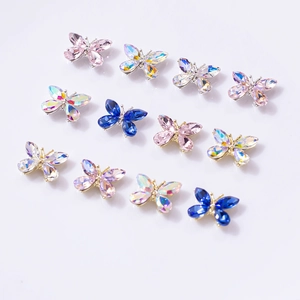 Vue détaillée des bijoux d'ongles papillon 3D avec verre facetté et montures métalliques