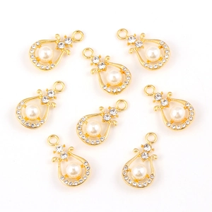 Pendentifs harpe dorés en alliage avec strass et perles sur fond blanc immaculé