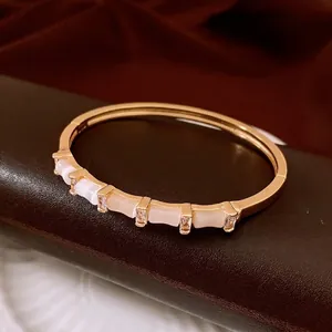 Bracelet doré style bambou avec cinq pierres œil-de-chat blanches et zircons cubiques