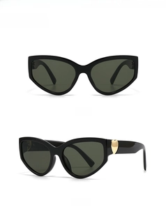 Detail view of cat eye sunglasses featuring gold heart accents on black frames