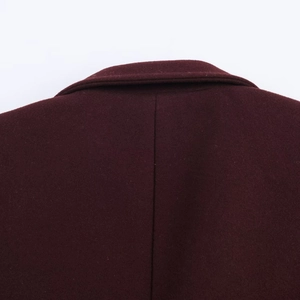 Close-up of the burgundy wool coat's back seam and high-quality collar texture details