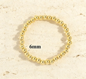 Detailed view showing 6mm 18K gold-plated beads on a minimalist elastic bracelet
