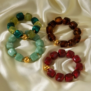 Detailed macro of vintage resin beaded bracelets with marble texture and gold accents