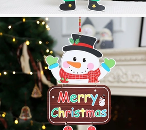Detail of Christmas snowman paper ornament with Merry Christmas sign on a festive tree