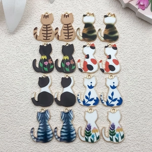 Flat lay of sixteen colorful cat-shaped enamel pendants for DIY jewelry and keychain making