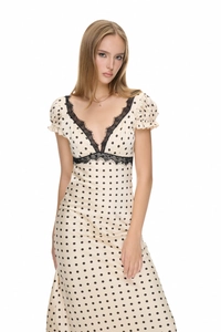 Detail of V-neckline with black lace trim on a beige polka dot french style dress