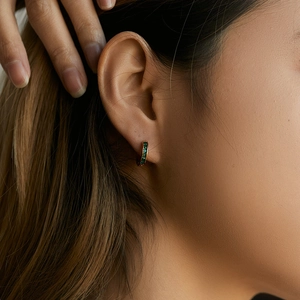 18K gold plated hoop earrings with turquoise stones worn by a model in a close-up view