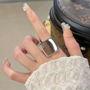 Close-up of a oversized square silver ring with a polished mirror finish on a model