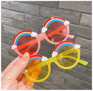 Detail of round kids sunglasses with colorful rainbow and white clouds decoration
