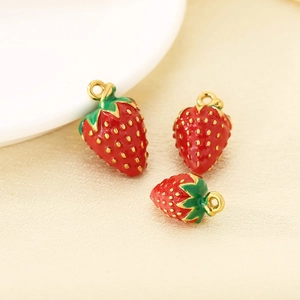 Three 304 stainless steel strawberry pendants for jewelry making on soft white fabric