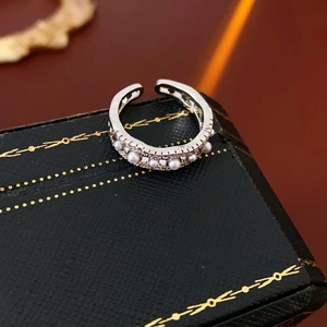 Close-up of vintage hollow silver ring with six pearls and zircon stones on a jewelry box